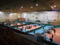 Sala główna z rozstawionymi stołami do tenisa stołowego oraz zawodnikami