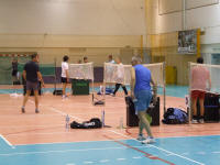 Uczestnicy na tle wyklejonych boisk do badmintona podczas otwarego turnieju badmintona