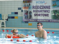 Dziecko i rodzic w wodzie wraz z kołem ratunkowym podczas rodzinnych rozgrywek sportowych - 2 runda