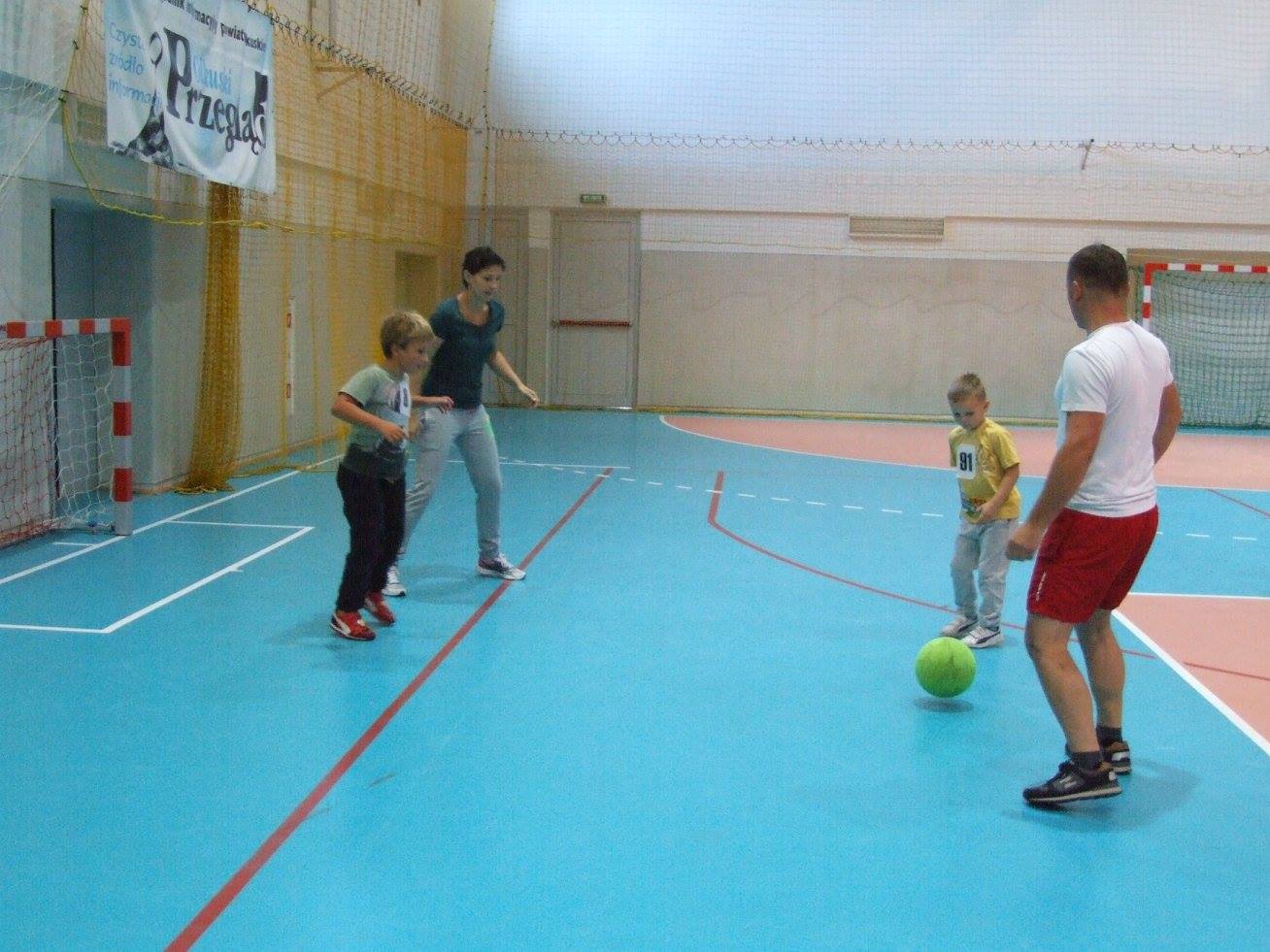 Dzieci grają w mini piłkę nożną wraz z rodzicami podczas rodzinnych rozgrywek sportowych