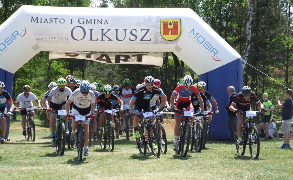 Rowerzyści startują spod bramy dmuchanej w wyścigu podczas XXIV Mistrzostw Polski w Kolarstwie Górskim Family Cup 2019 dla Amatorów