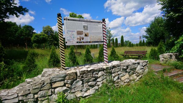 Fragment muru rosyjskiego Urzedu Celnego wraz z tablica informacyjną w Niesułowicach