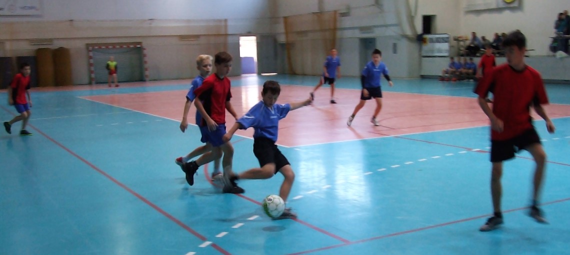 Uczniowie ze szkół podstawowych rozgrywają mecz podczas Igrzysk Dzieci w halowej piłce nożnej