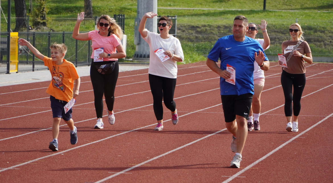 Uczestnicy eventu biegną na bieżni lekkoatletycznej